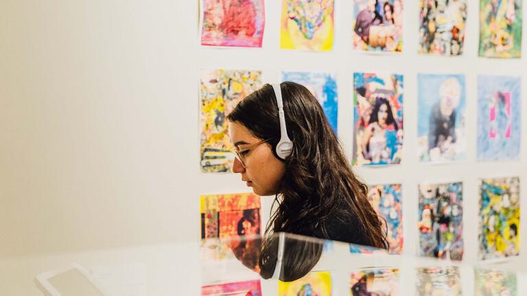 Person wearing headphones while at an art exhibit.