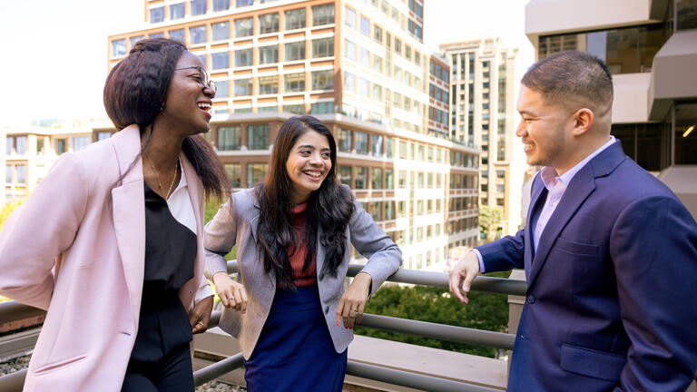 three students laughing together at downtown campus
