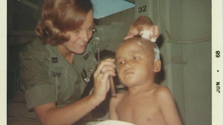 Linda Sharp helping a Vietnamese boy