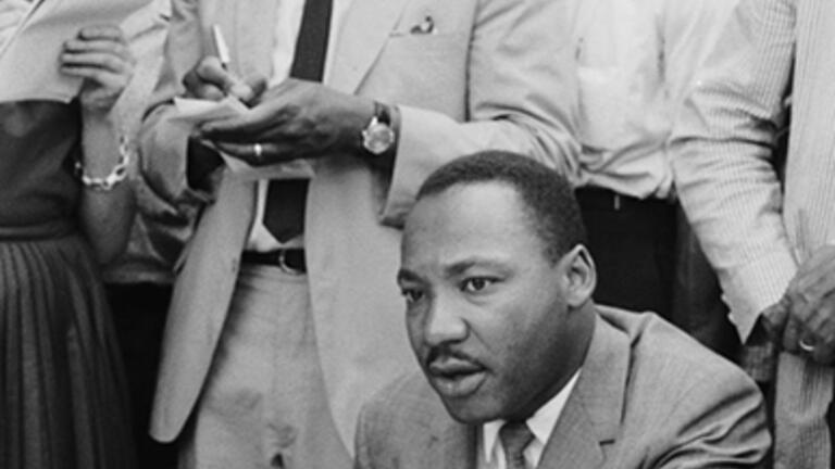 Clarence B. Jones, legal adviser to Martin Luther King Jr., takes notes behind King at a press conference regarding in Birmingham, Ala., in February 1963.