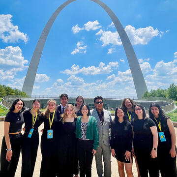 Group of students pose in front of the St Louis arch