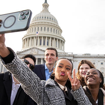 students taking a selfie in front of the united stated capitol building