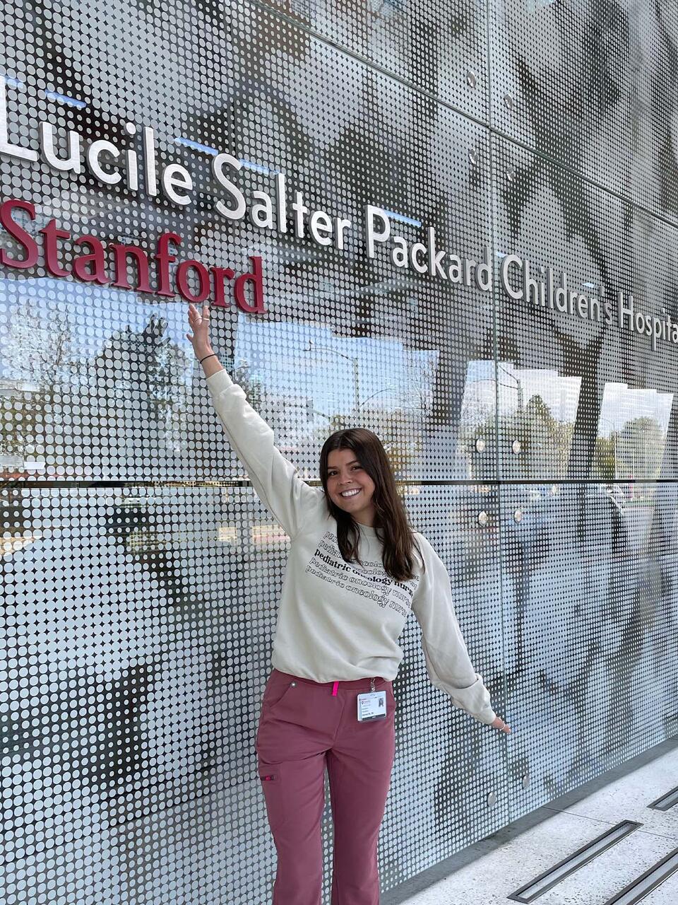 Hannah McCullough in front of Stanford Lucile Salter Packard sign
