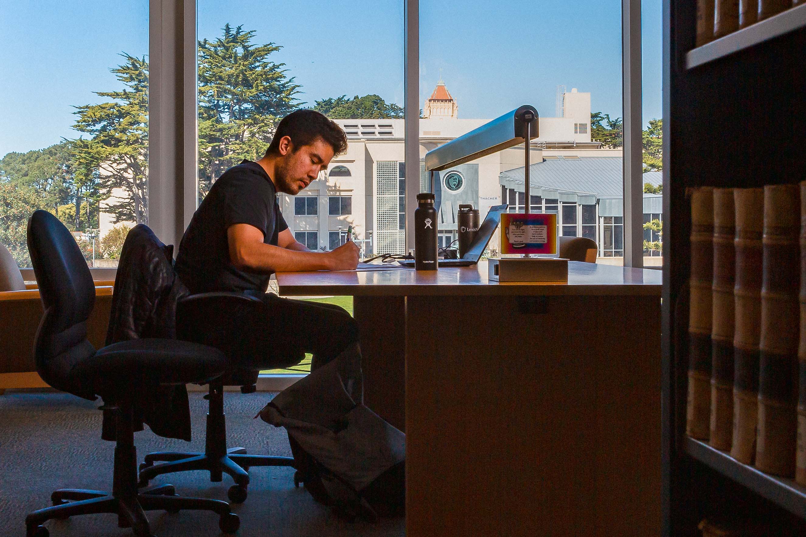 Student studies at a table in the library.