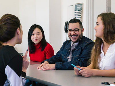 Professor discussing with students in her classroom