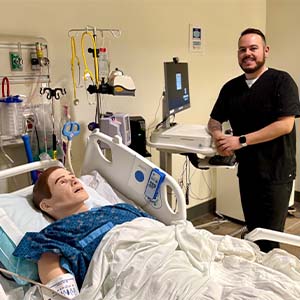 Anthony Alvarado with a mannequin patient