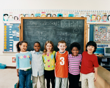 Students posing in front of chalkboard