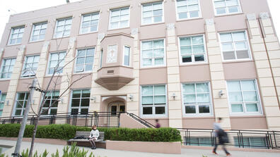 Students walk by one of the entrances to the School of Education building