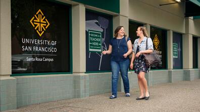 Two students walking in front of USF's Santa Rosa campus