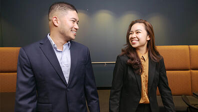 Two USF students in business-wear walking and chatting