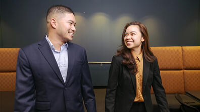 Two USF students in business-wear walking and chatting