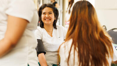 Nursing students practicing blood pressure screening during a campus health fair