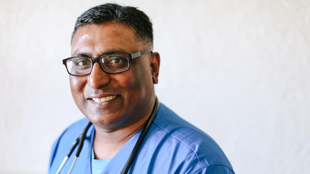 Vincent Samuel poses in scrubs with a stethoscope around his neck
