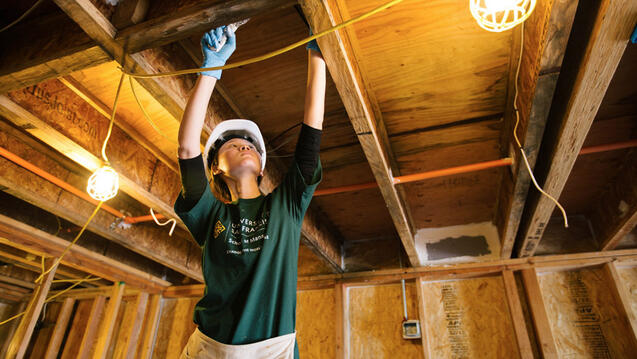 Student volunteering building a house