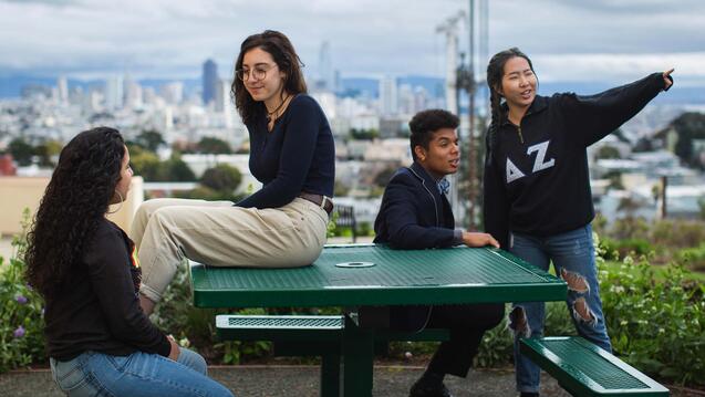 Students sit on a picnic table on Lone Mountain.