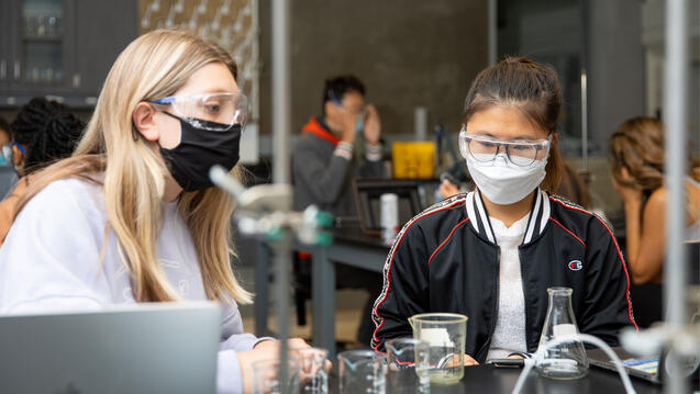 Two students work on an experiment in lab class.