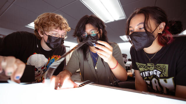 Students examine film at a light table.