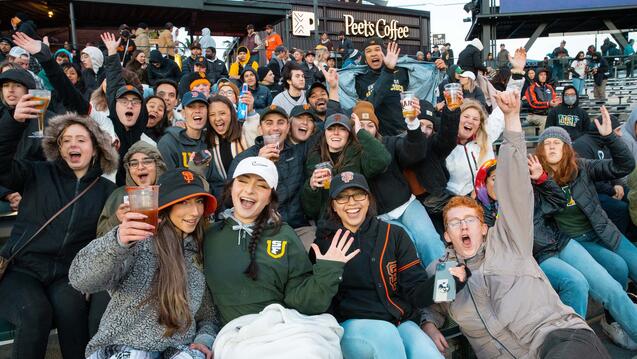 A group of USF students and alumni cheer together at SF Giants game.