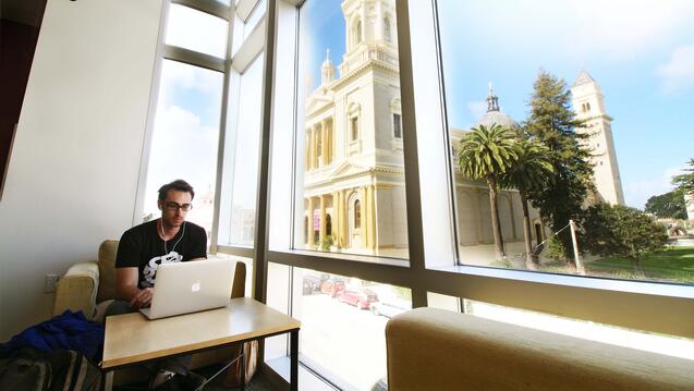Student studies in front a a window in Zief Library.