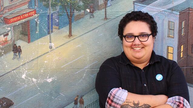 Nicky Martinez poses in front of a mural.