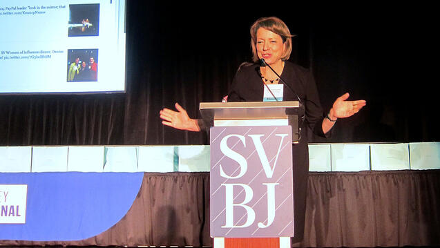 Mary Bartlett gives a speech behind a podium that reads SVBJ