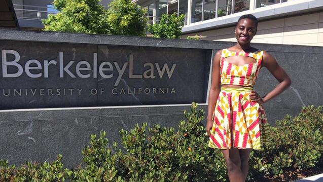 Akofa Tsiagbe stands in front of a sign for Berkeley school of law.