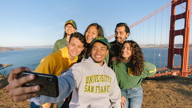 Group of students take a selfie in front of the Golden Gate Bridge.