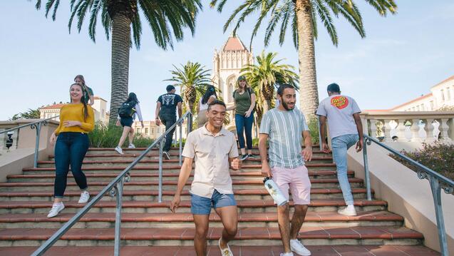 A number of students pass each other on the stairs leading to Lone Mountain.