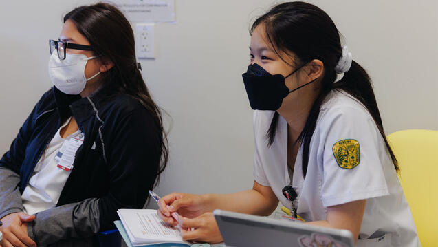 Nursing students sit at attention in class.