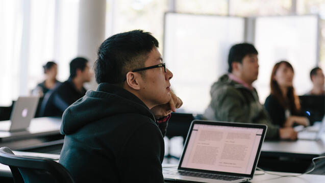 student in class with laptop