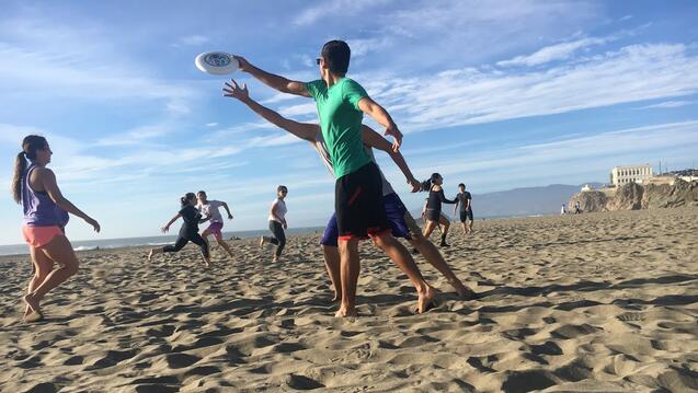 People playing with a frisbee on the beach