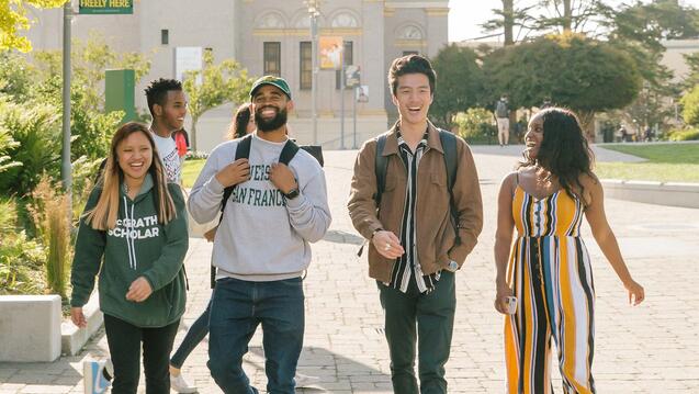 Students walk across campus on a sunny day