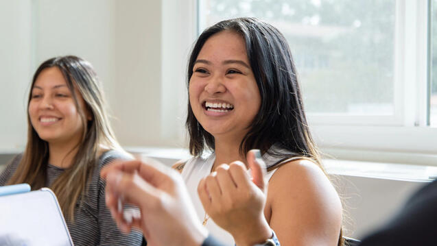 Student in classroom smiling and engaging in discussion