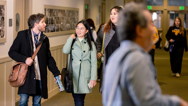 three students walk together outside classroom