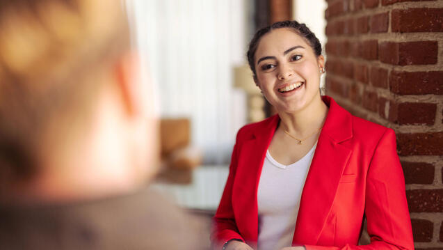 USF student in business attire chatting with another student