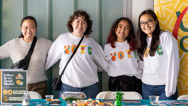 students standing at usf votes booth