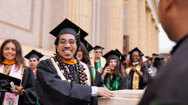 Graduate smiling outside of St. Ignatius church