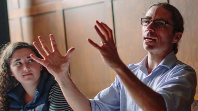 Professor teaching in a room to students