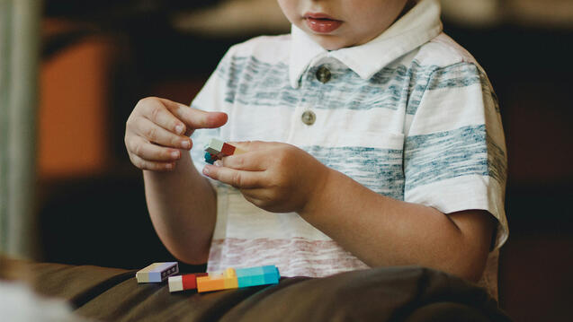 Young child playing with legos