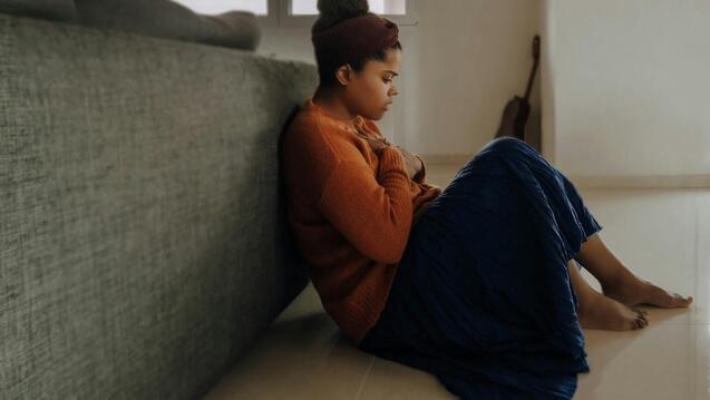 Child clutching her chest while sitting on the ground