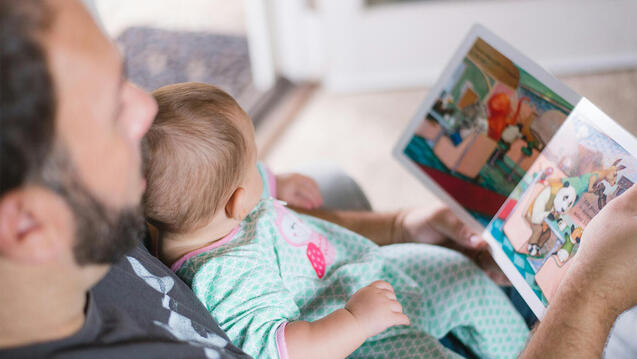 Father reading to infant child