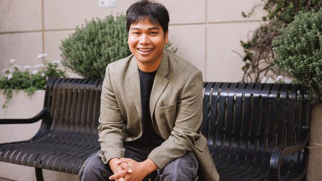 USF grad student sitting on a bench, smiling