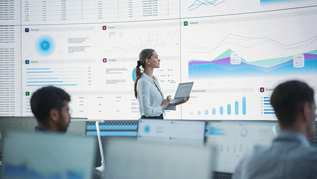 Business person analyzing data on large screens
