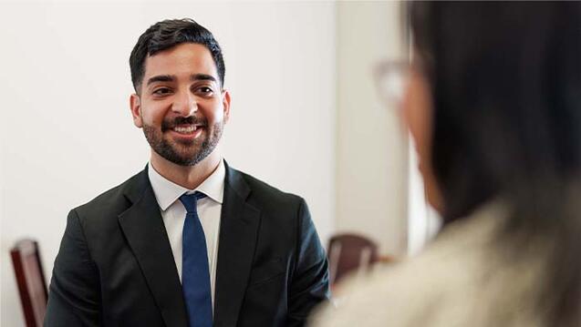 Person in a suit talking with another person