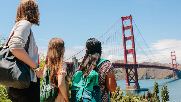 Three students look at the Golden Gate Bridge