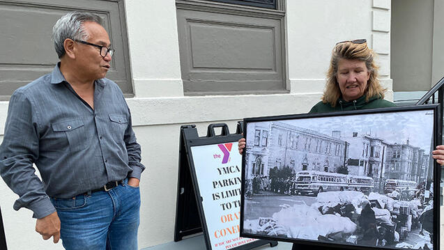 community partners standing outside holding a large poster