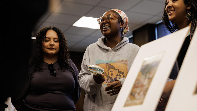 Museum studies students smiling, gathered around a table