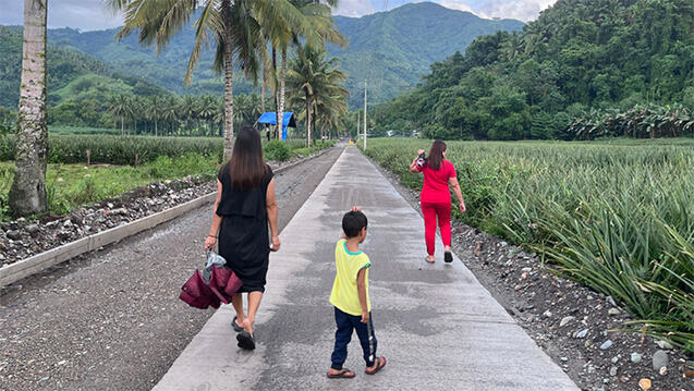 people walking along sidewalk in the philippines