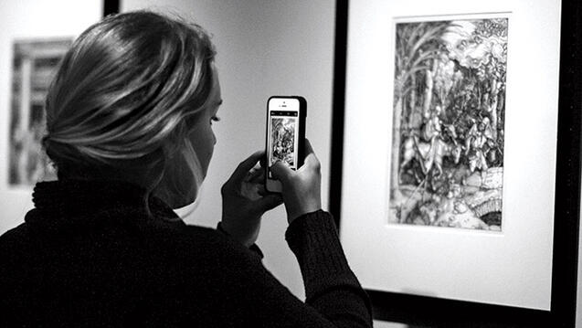 A student snaps a photo of Albrecht Dürer’s “Flight into Egypt,” a print that is part of the university’s permanent collection.