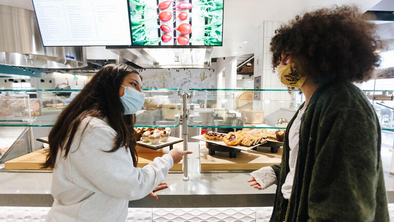 Two students select food at cafeteria.